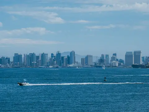 The San Diego skyline across the bay under a blue sky